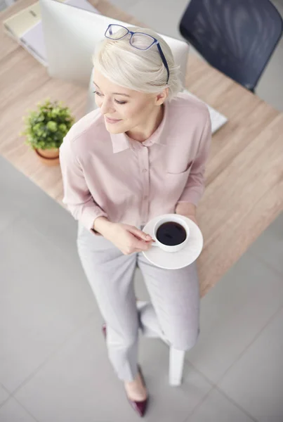 Osoba inteligentna działalności z kawy siedząc przy biurku — Zdjęcie stockowe