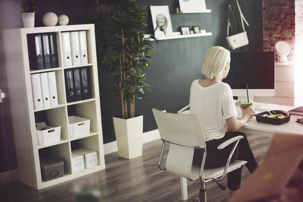 Zakenvrouw eten bij Bureau — Stockfoto