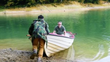 Bir balıkçı teknesi iterek adam 