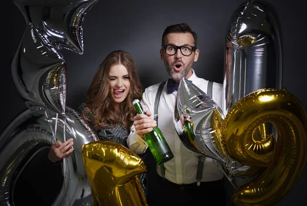Pareja alegre con champán y globos celebrando — Foto de Stock