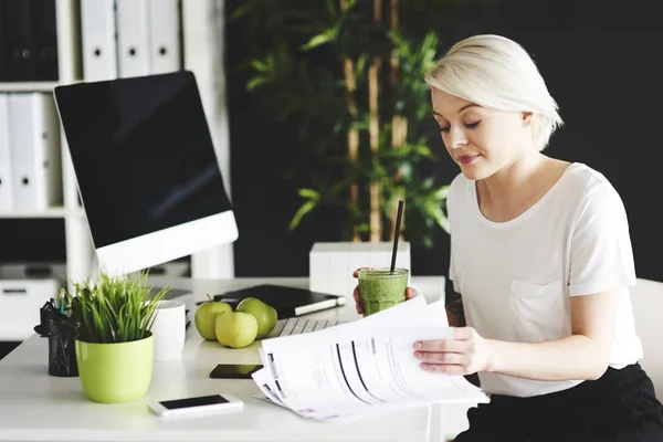 Geschäftsfrau liest wichtige Dokumente auf ihrem Schreibtisch — Stockfoto