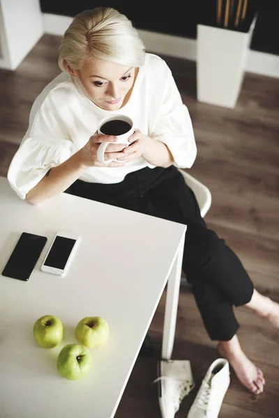 Kvinna med kaffe vilar hemma efter jobbet — Stockfoto