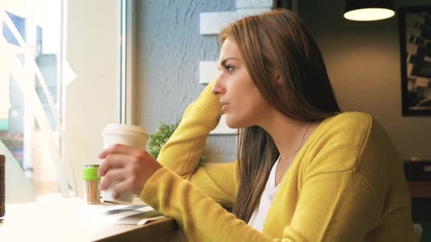 Mulher com café olhar através da janela — Vídeo de Stock