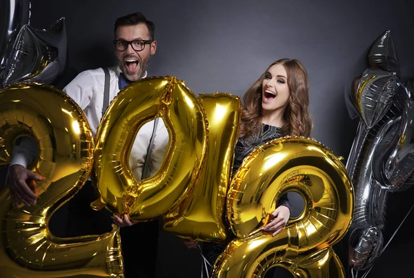 Pareja sorprendida sosteniendo el globo de año nuevo — Foto de Stock