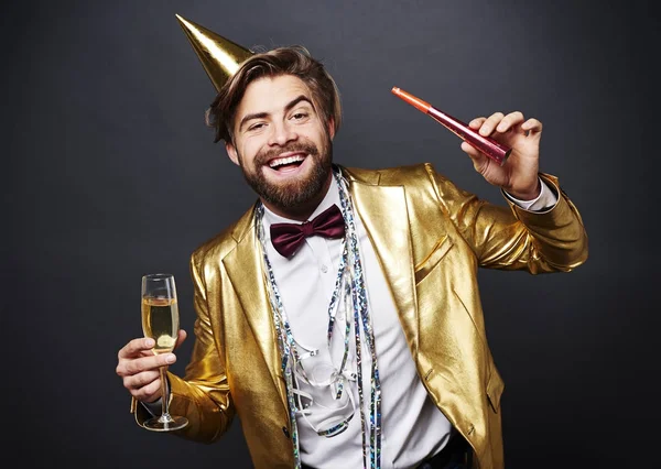 Retrato del hombre sonriente sosteniendo la flauta de champán y el ventilador de fiesta — Foto de Stock