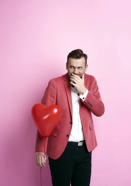 Man with heart shape balloon giggling — Stock Photo, Image