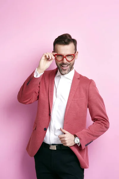 Fröhlicher Mann mit herzförmiger Brille posiert — Stockfoto