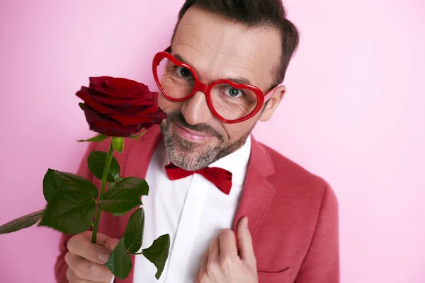Hombre de traje rojo sosteniendo una rosa — Foto de Stock