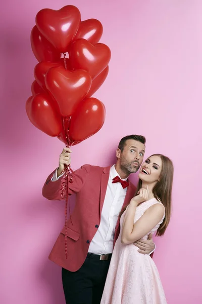 Aanhankelijk paar met hart vorm ballonnen flirten — Stockfoto