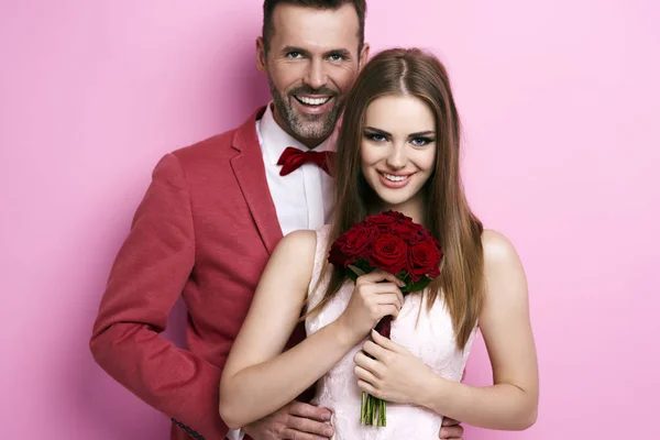 Retrato del hombre abrazando a la mujer con ramo de rosas —  Fotos de Stock