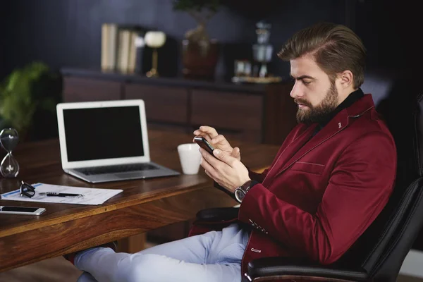 Бізнесмен використовує свій мобільний телефон в домашньому офісі — стокове фото