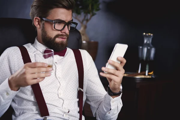 Geschäftsmann benutzt sein Smartphone und trinkt Tee — Stockfoto