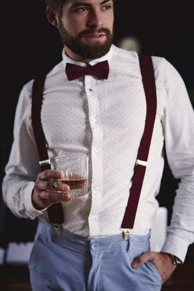 Bonito homem de negócios segurando um copo de uísque — Fotografia de Stock