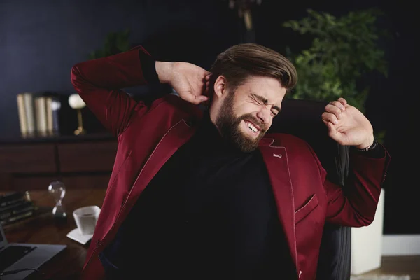 Businessman stretching at his desk — Stock Photo, Image