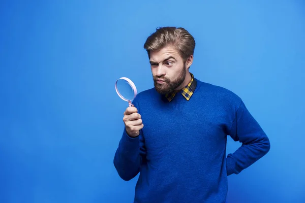Surprised man looking through a magnifying glass — Stock Photo, Image