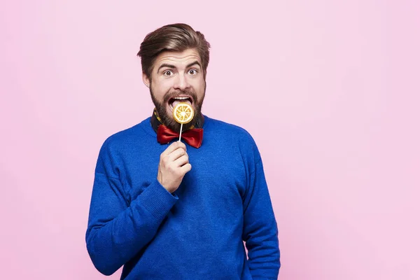 Man licking a lollipop at studio shot — Stock Photo, Image