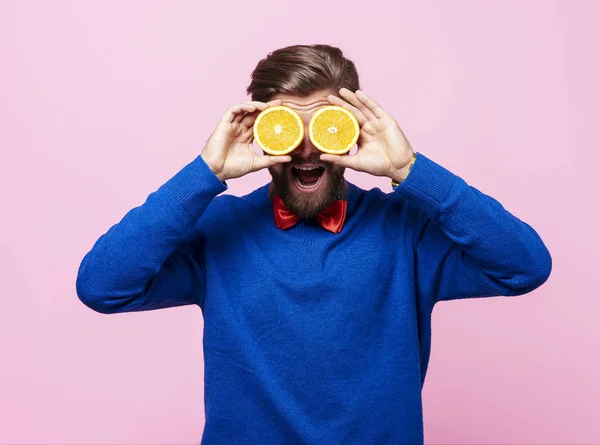 Mannen innehar två hälften av orange framför ögonen — Stockfoto