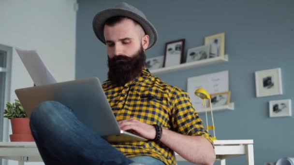 Сконцентрированный человек с бородой с помощью ноутбука — стоковое видео