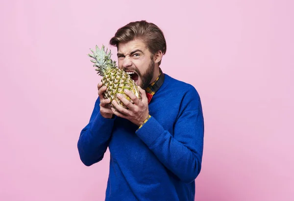 Hladový člověk hltá ananas — Stock fotografie