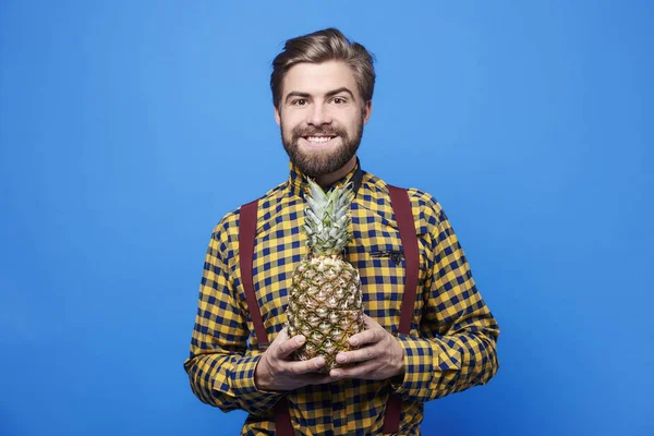 Front view of man holding a pineapple — Stock Photo, Image