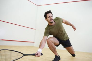 Man during squash match on cour clipart