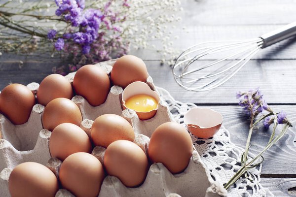 Broken egg among eggs in egg box