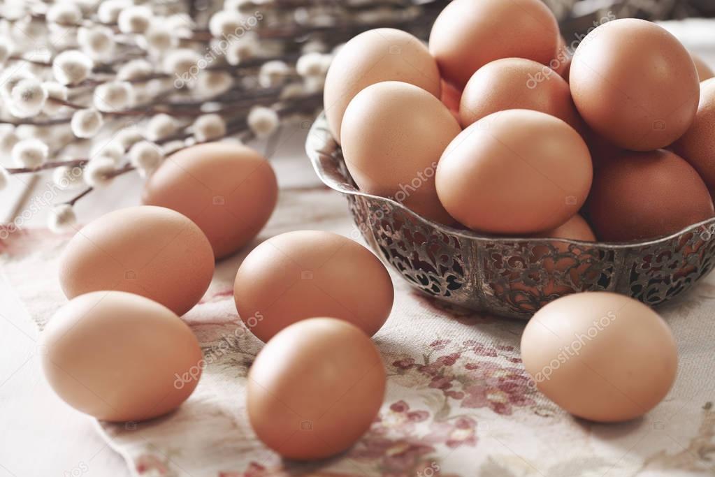 Brown eggs and catkin on table