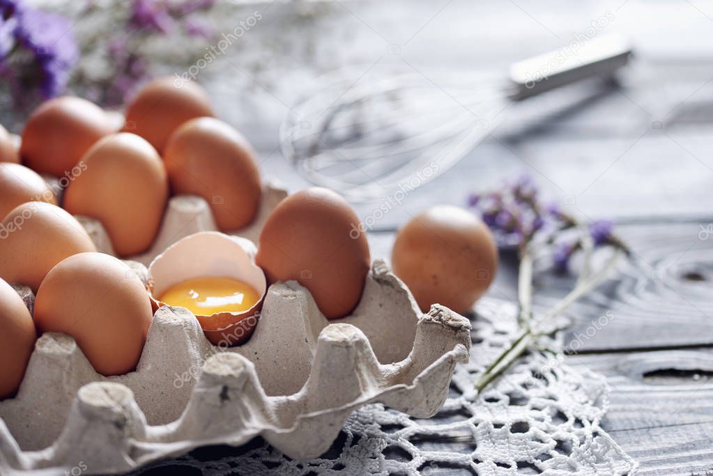 Broken egg among brown eggs in egg box