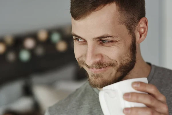 笑みを浮かべて男の寝室でコーヒーを飲んで — ストック写真