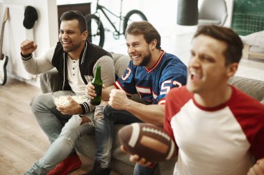 Amerikan futbolu izlerken heyecanlı futbol taraftarları