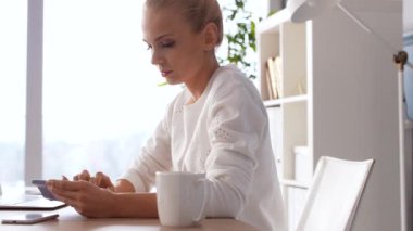 Onun ofisinde bir hesap makinesi ile endişeli kadın 