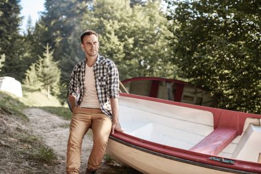 Kayığın ormanının üzerinde oturan adam