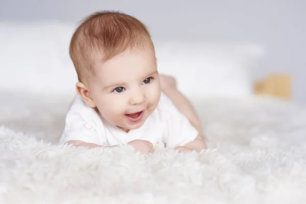 Cheerful baby lying on front