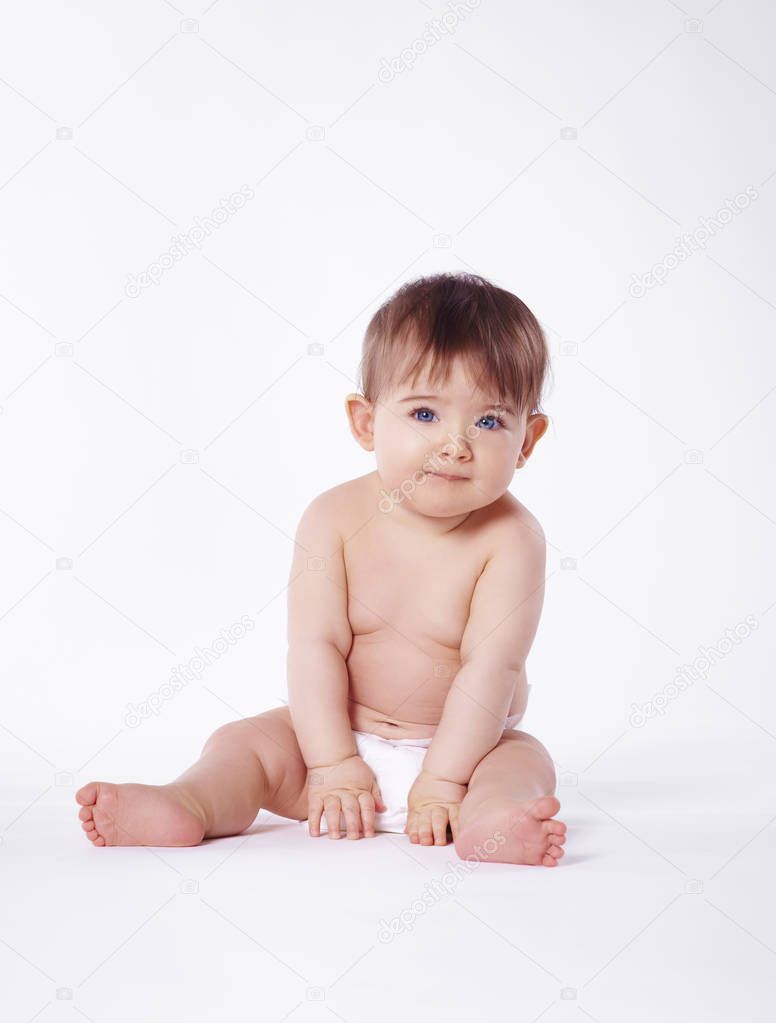 Portrait of naked baby sitting at studio shot 