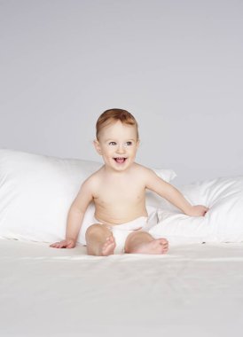 Yatağın üstüne oturan bebek 