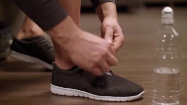 Spor ayakkabısını bağlayan adam