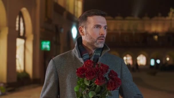 男人拿着一束玫瑰等着他的女人 — 图库视频影像