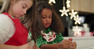 Noel kurabiyelerini süsleyen iki küçük kızın el kamerasıyla çekilmiş görüntüleri. 