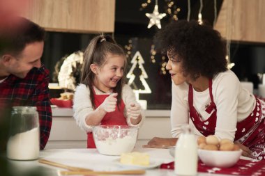 Parents and child baking cookies in the kitchen