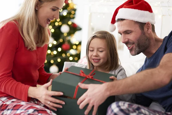 家族はベッドで贈り物を開くことからクリスマスを開始 — ストック写真