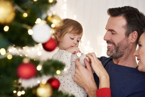 クリスマスツリーを飾る赤ちゃんの両親 — ストック写真