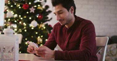 Cep telefonlu bir adam Noel için en iyi dileklerini gönderiyor.