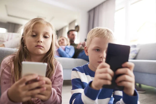 携帯電話を見ている集中的な子供たち — ストック写真