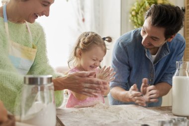 Mutfakta un ile oynayan mutlu bir aile. 