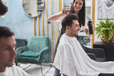 Kuaför, erkek müşterisinin son moda saç stilini oluşturuyor.