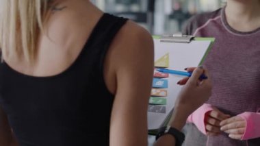 Handheld view of fitness instructor giving advice .  Shot with RED helium camera in 8K