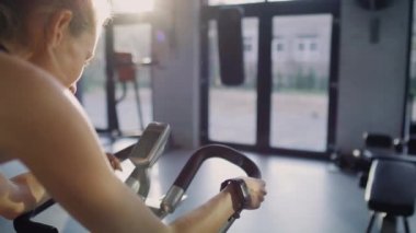 Handheld view of woman with kettlebell exercising at gym.  Shot with RED helium camera in 8K
