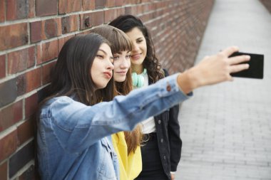 Hipster friends making a selfie by mobile phone 