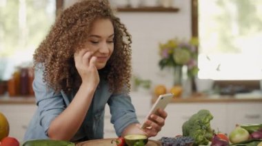 Mutfakta cep telefonu olan genç bir kadının el kamerası görüntüsü.