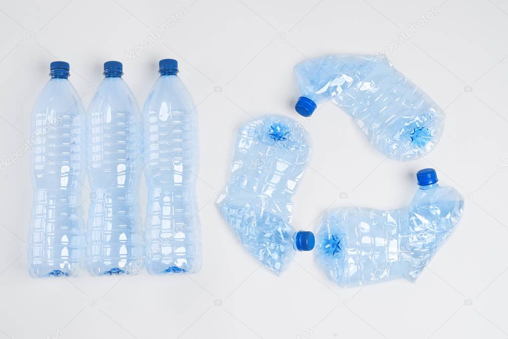 Recycling symbol made of plastic bottles on white background 